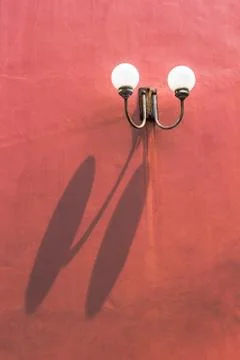 Two llight on red wall with shadow Stock Photos