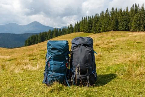 Two load backpacks standing on the background of beautiful mountain view. Couple Stock Photos