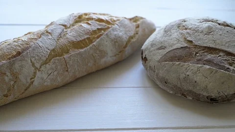 Two loaves of bread on white wood Stock Footage 77659657