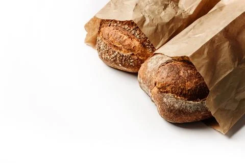 Two loaves of fresh rustic bread in craft bags Stock Photos