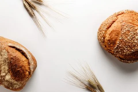 Two loaves of tasty rustic bread and ears of wheat Stock Photos