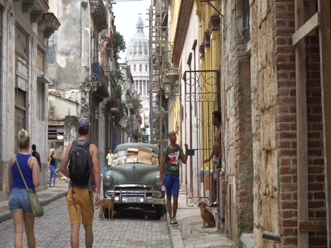 Two local latino men talk with each other near broken old green retro car parked Vídeos de archivo 70853349