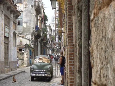 Two local men are standing near broken old green retro car parked on road Stock Footage 70852457
