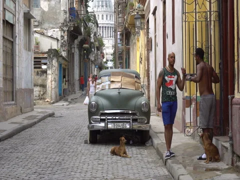 Two local men are talking with each other near broken old green retro car parked Stock Footage 70852468