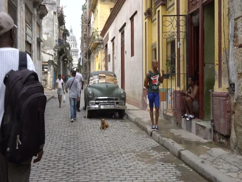 Two local men have conversation near broken old green retro car parked on road Stock Footage 70852743
