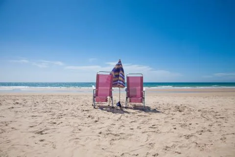 Two lonely chairs looking at ocean Stock-Fotos