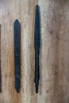 Two long black objects are on a wooden surface. in Chennai Stock Photos