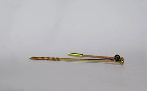 Two long yellow self-tapping screws on a white background. Stock Photos