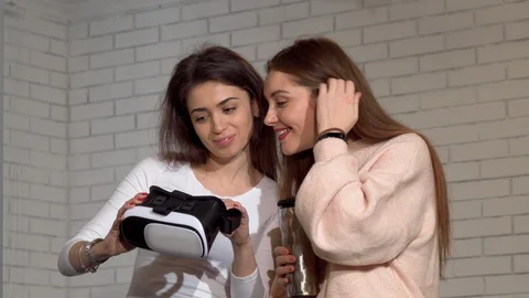 Two lovely female friends using 3d virtual reality goggles together Stock Footage 105020089