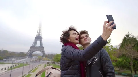 Two lovers are taking selfies by smartphone in Paris, photographing their face Stock Footage 98809976