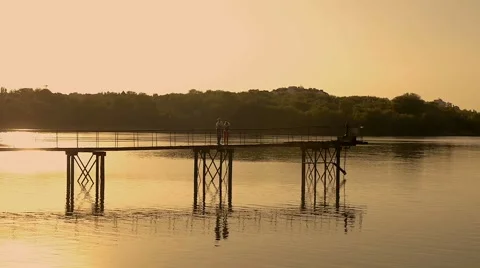 Two lovers on a bridge at sunset Stock Footage 68809556