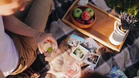 Two lovers drink a local drink at a picnic in the park. Cool close-up Stock Footage 247569928