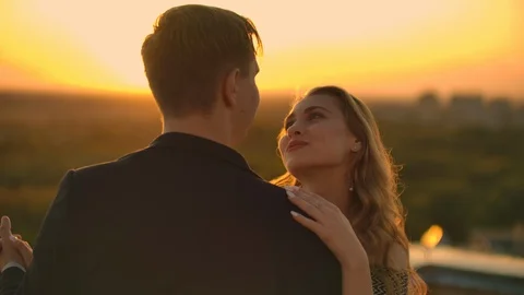 Two lovers embracing dancing on top of a skyscraper overlooking the city at Vídeo Stock 116021515