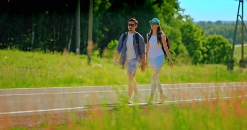 Two lovers go with backpacks on the road, travel. Hiking, beautiful landscape Stock Footage 134573840