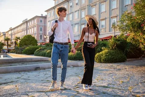 Two lovers hand in hand chat while looking into each other's eyes during a .. Stock Photos