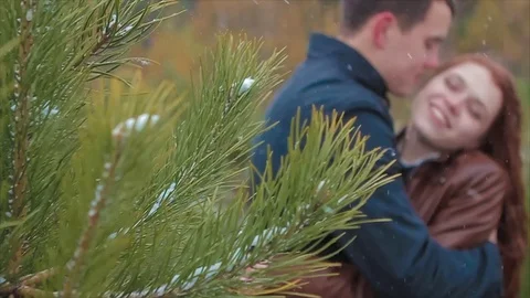 Two Lovers Kissing During Snowfall in Forest Stock Footage 71811912