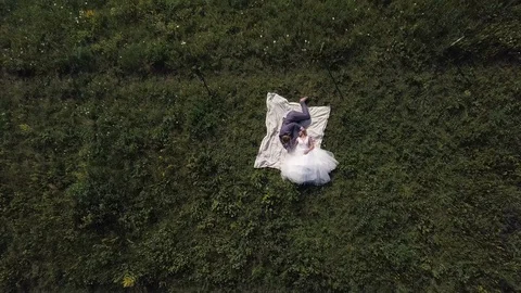 Two lovers lying on the grass from a height Stock Footage 126825185