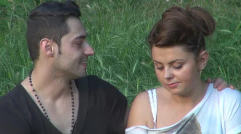 Two lovers sitting on the grass, talking. laughing 스톡 동영상 25503587