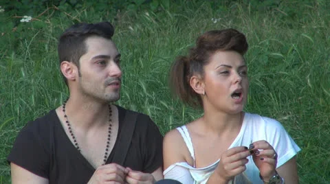 Two lovers sitting on the grass, talking. laughing 스톡 동영상 25505085