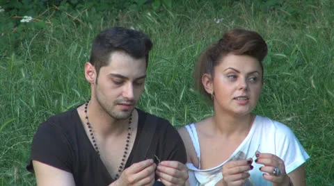 Two lovers sitting on the grass, talking. laughing 스톡 동영상 25505165