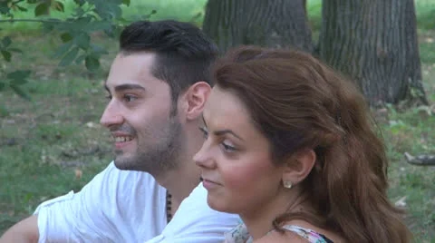 Two lovers sitting on the grass, talking. laughing 스톡 동영상 25540866