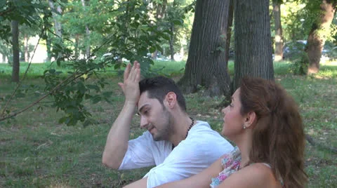 Two lovers sitting on the grass, talking. laughing 스톡 동영상 25540887