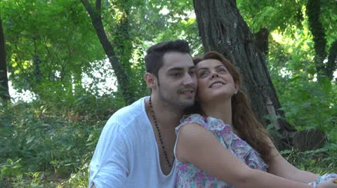 Two lovers sitting on the grass, talking. laughing 스톡 동영상 25540966