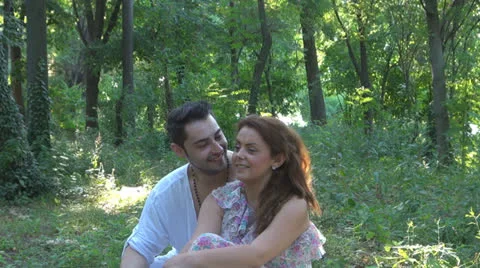 Two lovers sitting on the grass, talking. laughing 스톡 동영상 25541818