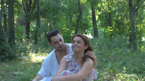 Two lovers sitting on the grass, talking. laughing 스톡 동영상 25541827