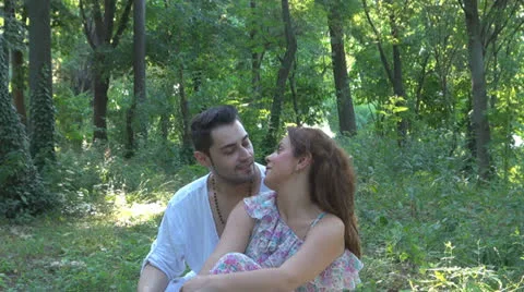 Two lovers sitting on the grass, talking. laughing 스톡 동영상 25541829