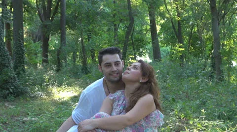 Two lovers sitting on the grass, talking. laughing 스톡 동영상 25541830