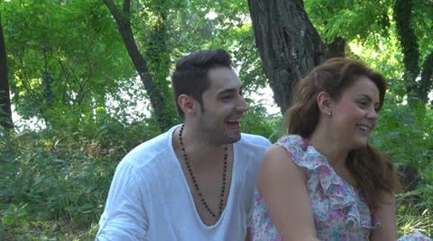 Two lovers sitting on the grass, talking. laughing 스톡 동영상 25541831