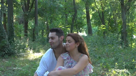 Two lovers sitting on the grass, talking. laughing 스톡 동영상 25541832