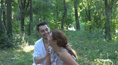 Two lovers sitting on the grass, talking. laughing 스톡 동영상 25541842