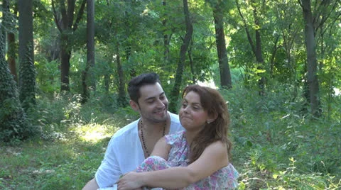 Two lovers sitting on the grass, talking. laughing 스톡 동영상 25541844