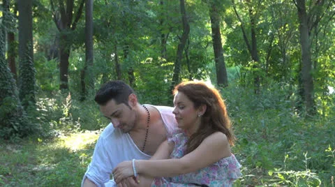 Two lovers sitting on the grass, talking. laughing 스톡 동영상 25541858