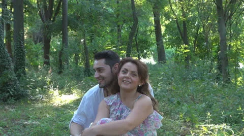 Two lovers sitting on the grass, talking. laughing 스톡 동영상 25541859