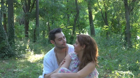 Two lovers sitting on the grass, talking. laughing 스톡 동영상 25541865