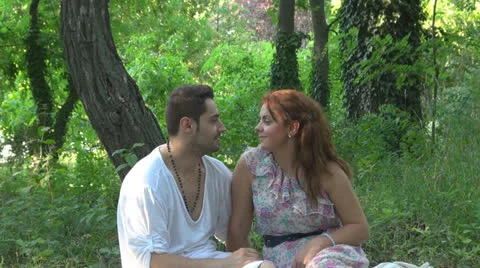 Two lovers sitting on the grass, talking. laughing 스톡 동영상 25543602