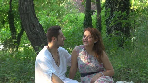 Two lovers sitting on the grass, talking. laughing 스톡 동영상 25543636