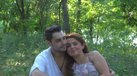 Two lovers sitting on the grass, talking. laughing 스톡 동영상 25543662