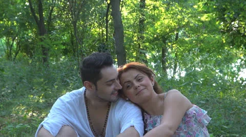 Two lovers sitting on the grass, talking. laughing 스톡 동영상 25543680