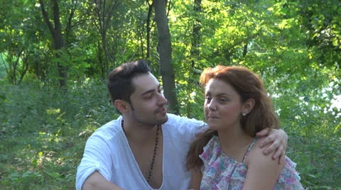 Two lovers sitting on the grass, talking. laughing 스톡 동영상 25543685