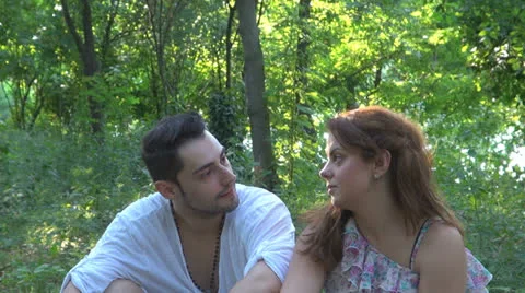 Two lovers sitting on the grass, talking. laughing 스톡 동영상 25543691