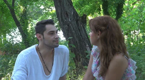 Two lovers sitting on the grass, talking. laughing 스톡 동영상 25543703