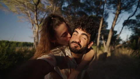 Two lovers smile and take pictures of each other in a forest Video stock 257581925