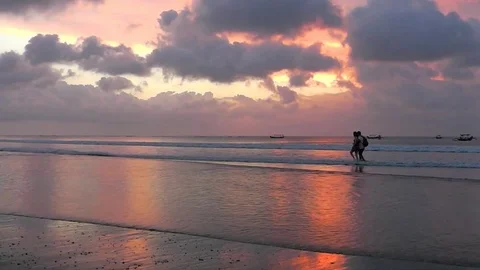 Two lovers walk at the sunset along the Kuta beach. Bali island. 스톡 동영상 81427734