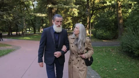 Two loving elderly people walking in a beautiful green area. Stock Footage 323915812