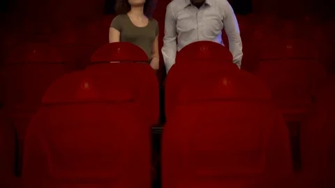 Two loving in the great, empty hall of the cinema with red chairs Video stock 75040172