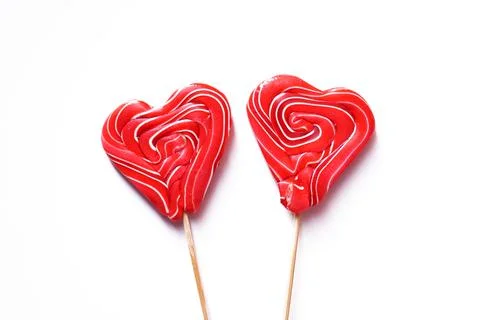 Two lozenges are multi-colored in the shape of a heart. Isolated on a white Stock Photos